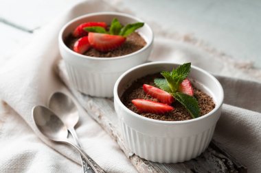 Tiramisu yatay beyaz masada ramekins içinde