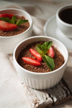 Tiramisu dikey beyaz masada ramekins içinde
