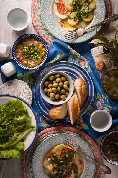 Cena griega con platos tradicionales en la mesa blanca vertical — Foto de Stock