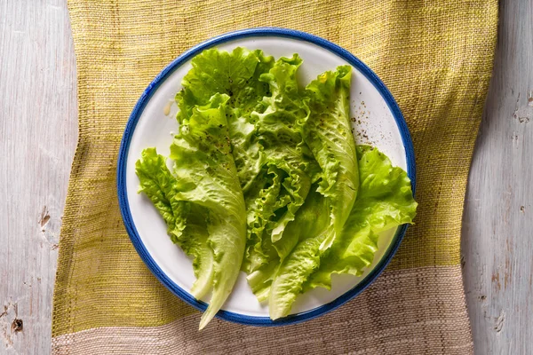 Ensalada verde en plato de cerámica en la mesa de madera blanca vista superior — Foto de Stock