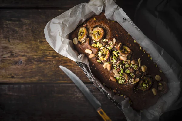 Banana ciasto w formie do pieczenia na widoku z drewniany blat — Zdjęcie stockowe