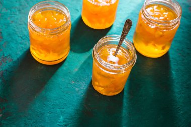 Turkuaz bir masada ananas dört kavanoz reçel