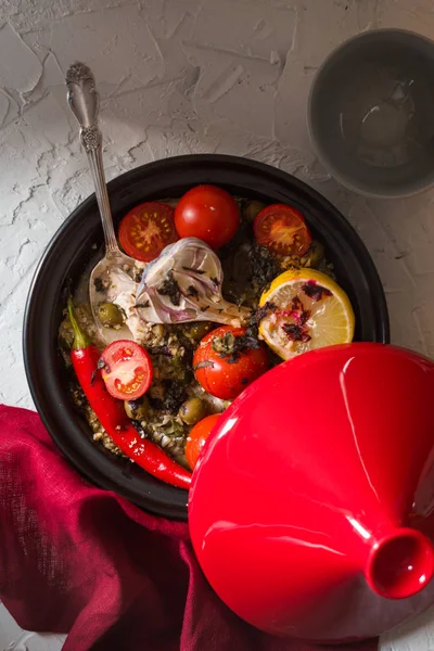 Red tazhin with vegetables, napkin and spoon on a white background — Stock Photo, Image