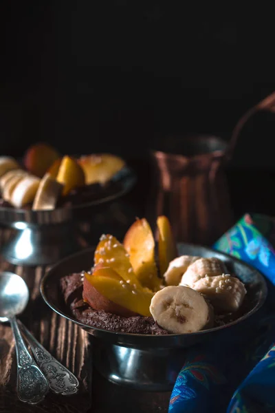 Chocolate mousse with peach and bananas on the wooden table — Stock Photo, Image