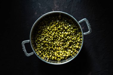 Koyu arka plan üstten görünüm üzerinde metal tencerede Mung fasulye