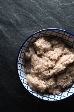 Bir kase gri bir taş üzerinde yararlı arpa yulaf lapası