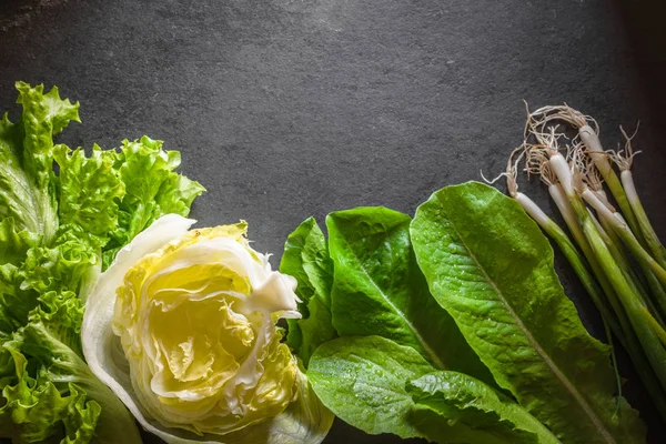 Ensalada de iceberg, cebollas verdes y espinacas sobre pizarra gris — Foto de Stock