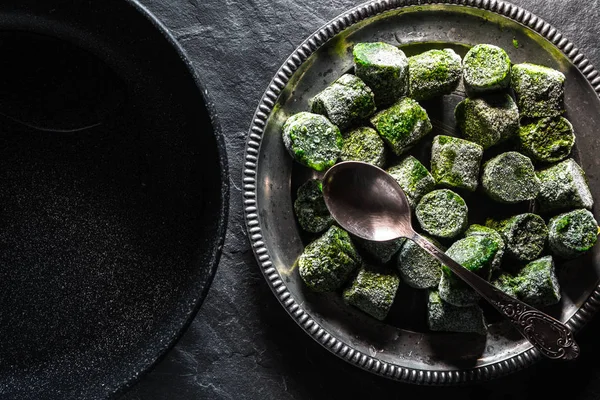 Frozen spinach in a tin plate and frying pan — Stock Photo, Image