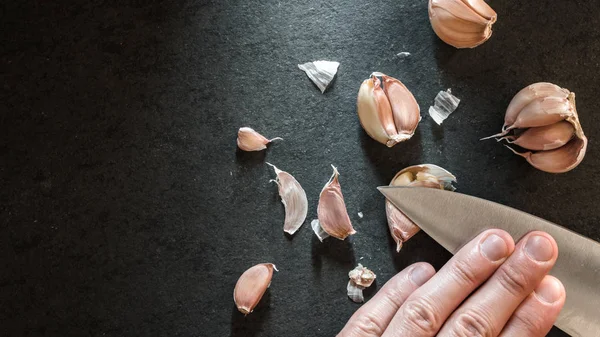 Ξεφλούδισμα το σκόρδο με ένα μαχαίρι — Φωτογραφία Αρχείου