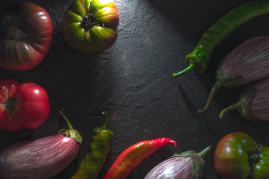 Chili, çok renkli domates ve patlıcan bir gri tablosudur boş alan üzerinde çerçeve