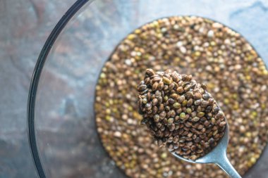 Kenevir tohumu ve mavi taş yakın çekim bir kaşık ile cam kase