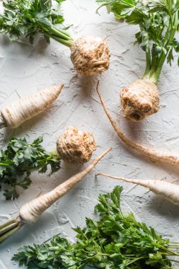 Kereviz kök ve maydanoz yaprakları beyaz bir tablo ile