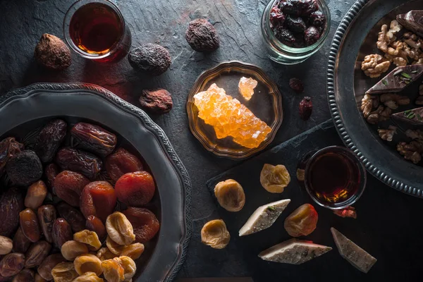 Trockenfrüchte, Nüsse auf einem Teller und Tee auf einem grauen Schiefer — Stockfoto
