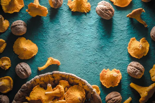Frame van cantharellen en walnoten op een turquoise tafel — Stockfoto