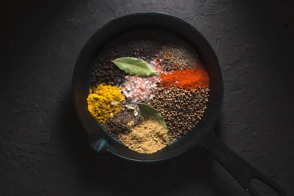 Diferentes especias para masala india en la sartén en la vista superior de fondo oscuro — Foto de Stock