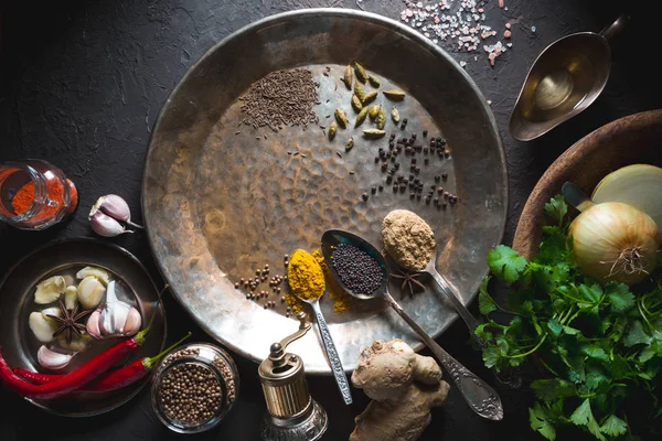 Yatay koyu arka plan üzerinde metal plaka üzerindeki farklı baharatlar