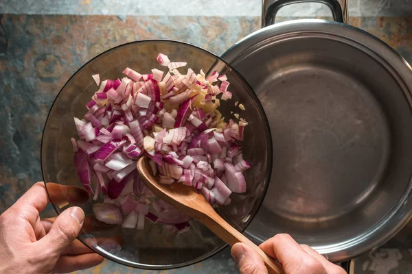 Des morceaux d'oignons rouges dans un bol en verre et une casserole — Photo