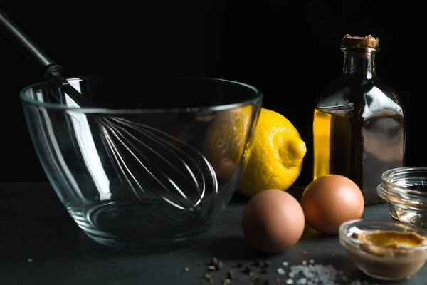 Яйца, оливковое масло, горчица на черном фоне — стоковое фото