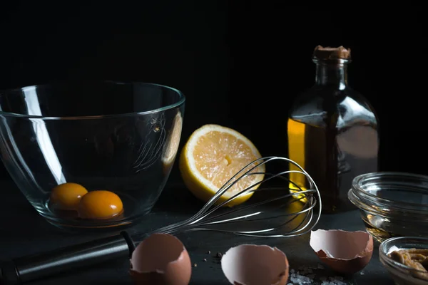 Желтки в миске, взбивка, горчица и оливковое масло вид сбоку — стоковое фото