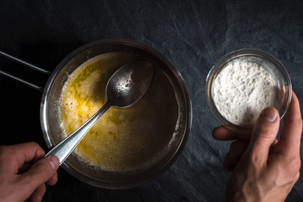 Un içine eritilmiş tereyağı yakın çekim ile bir tencereye dökülür