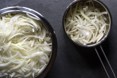 Bir kase ve bir tencerede soğan çorbası için payet ile soğan dilimlenmiş