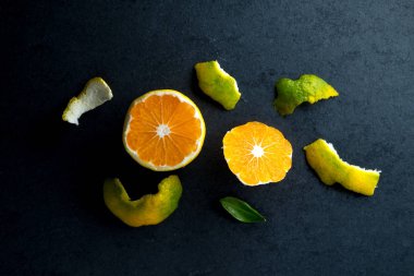 Soyulmuş sarı mandarin ve gri bir tablo kabuğuna