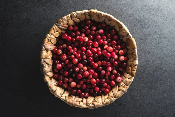 Red cranberries in a basket on a gray stone — Stock Photo, Image