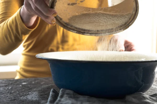 White flour is sieved in a large blue bowl — Stock Photo, Image