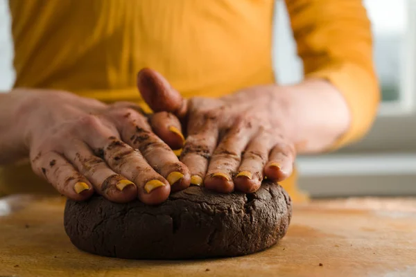 Ball of dough and cocoa pressed to a wooden board with your hands — Stock Photo, Image