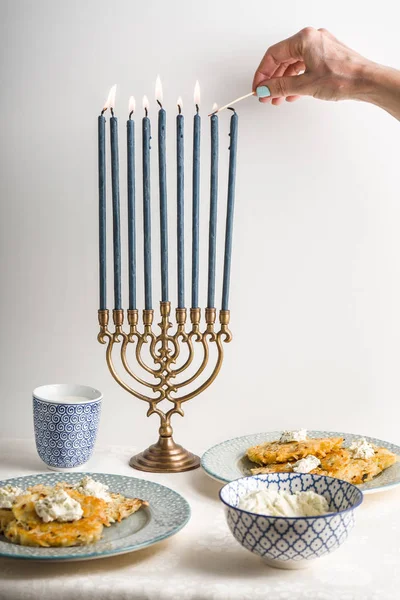 Hanukkah com velas acesas, latkes em um prato, queijo coalhado — Fotografia de Stock