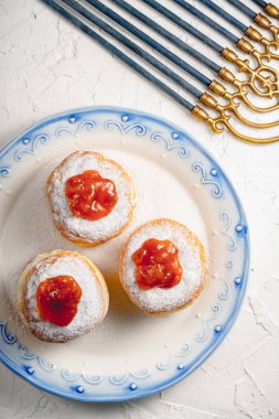 Bir mavi jant ve Hanukkah closeup ile bir tabakta reçelli çörek