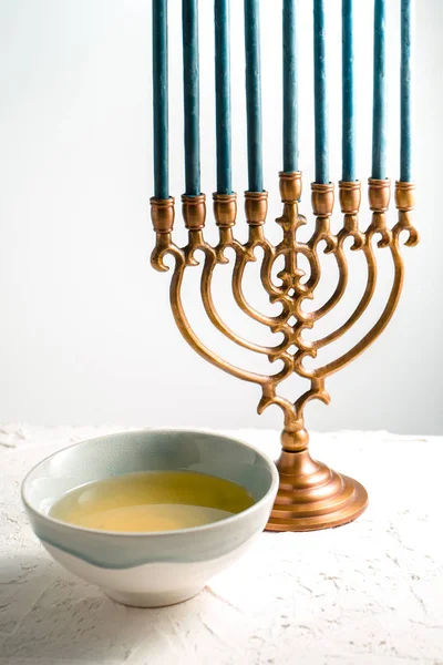 Menorah bronze Hanukkah com velas azuis e manteiga na tigela vista lateral — Fotografia de Stock