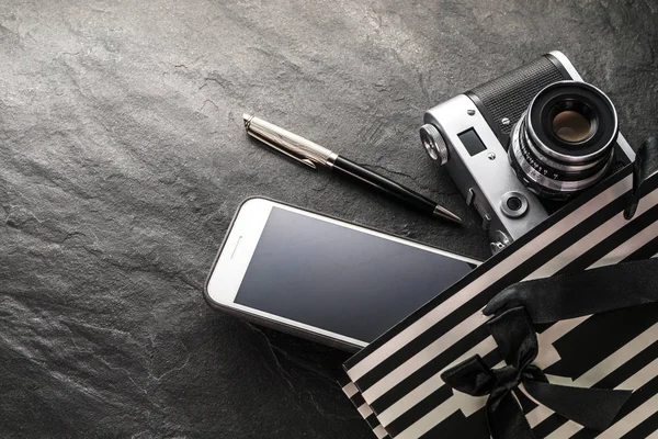 Telefone, câmera, caneta em um saco preto com tiras brancas espaço livre — Fotografia de Stock