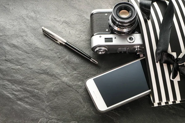 Telefone, câmera, caneta em um pacote preto com listras brancas com a direita — Fotografia de Stock