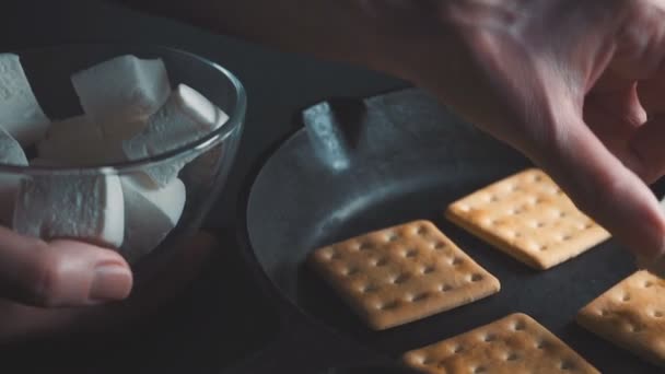 Colocando uma mão marshmalla fora de uma tigela em biscoitos quentes — Vídeo de Stock