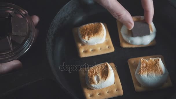 Aanbrengen van de stukken van chocolade op de marshmallow — Stockvideo