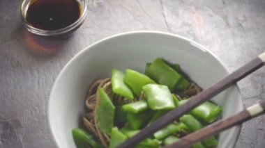 Buğday noodle yeşil fasulye bir seramik kase ve sopa ile
