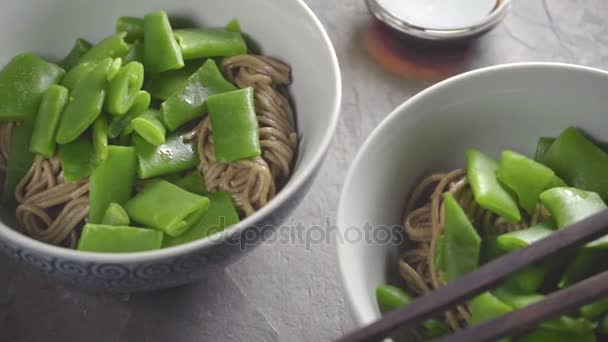 Two servings of buckwheat noodles with green beans — Stock Video