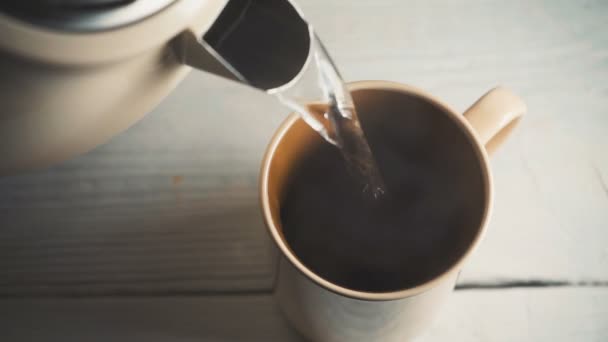 Fyller kaffe i en keramisk kopp med hett vatten från vattenkokare — Stockvideo