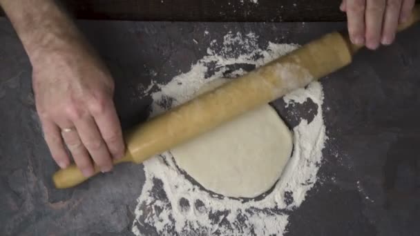Roulez la pâte avec un rouleau à pâtisserie pour une pizza maison. Vidéo — Video