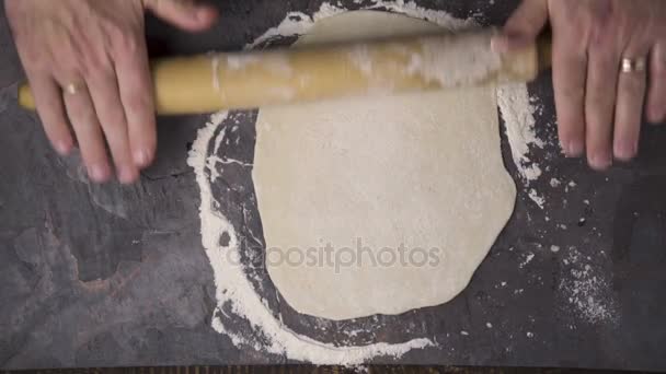 Extiende la masa para pizza sobre una mesa de piedra. Vídeo — Vídeo de stock