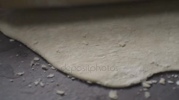 A massa de farinha fina estendida em uma mesa de pedra. Vídeo — Vídeo de Stock