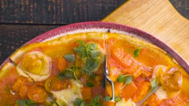 Evde pizza Margarita yukarıdan parçalar halinde kesilir. Video