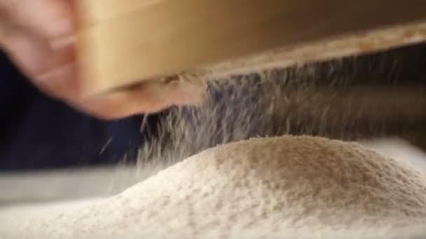 Sorseggiando farina e un setaccio nelle mani di un uomo. Video. — Video Stock