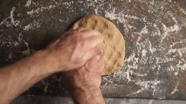 El hombre amasa la masa para la pasta en la mesa. Vídeo — Vídeo de stock