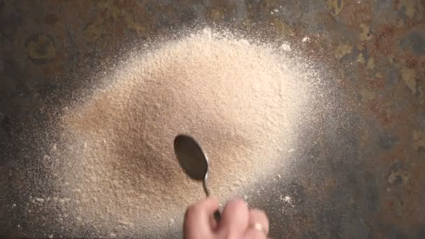 El hombre hace un agujero con una cuchara en una pila de harina. Vídeo — Vídeo de stock