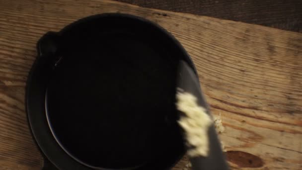 Knoflook opleggen een gietijzeren koekenpan. Video — Stockvideo