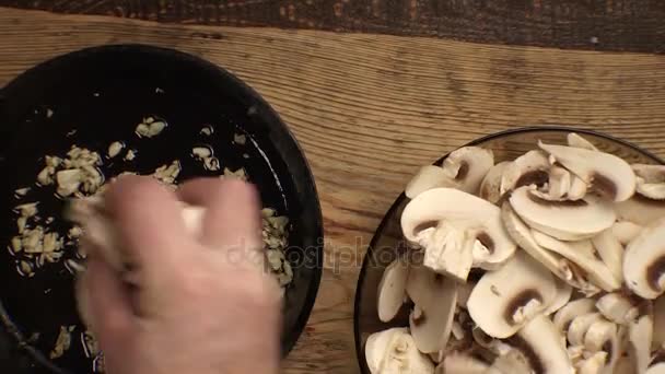 Coloque o alho e os cogumelos em uma panela. Vídeo — Vídeo de Stock