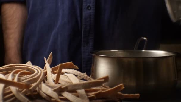 Homem de camisa azul está se preparando para cozinhar o close-up de macarrão trenette. Vídeo — Vídeo de Stock