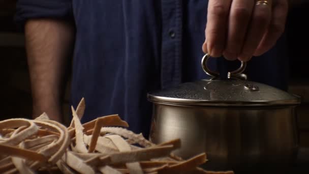 Ein Mann im blauen Hemd bereitet sich darauf vor, die Trenette-Pasta zu kochen. Video — Stockvideo